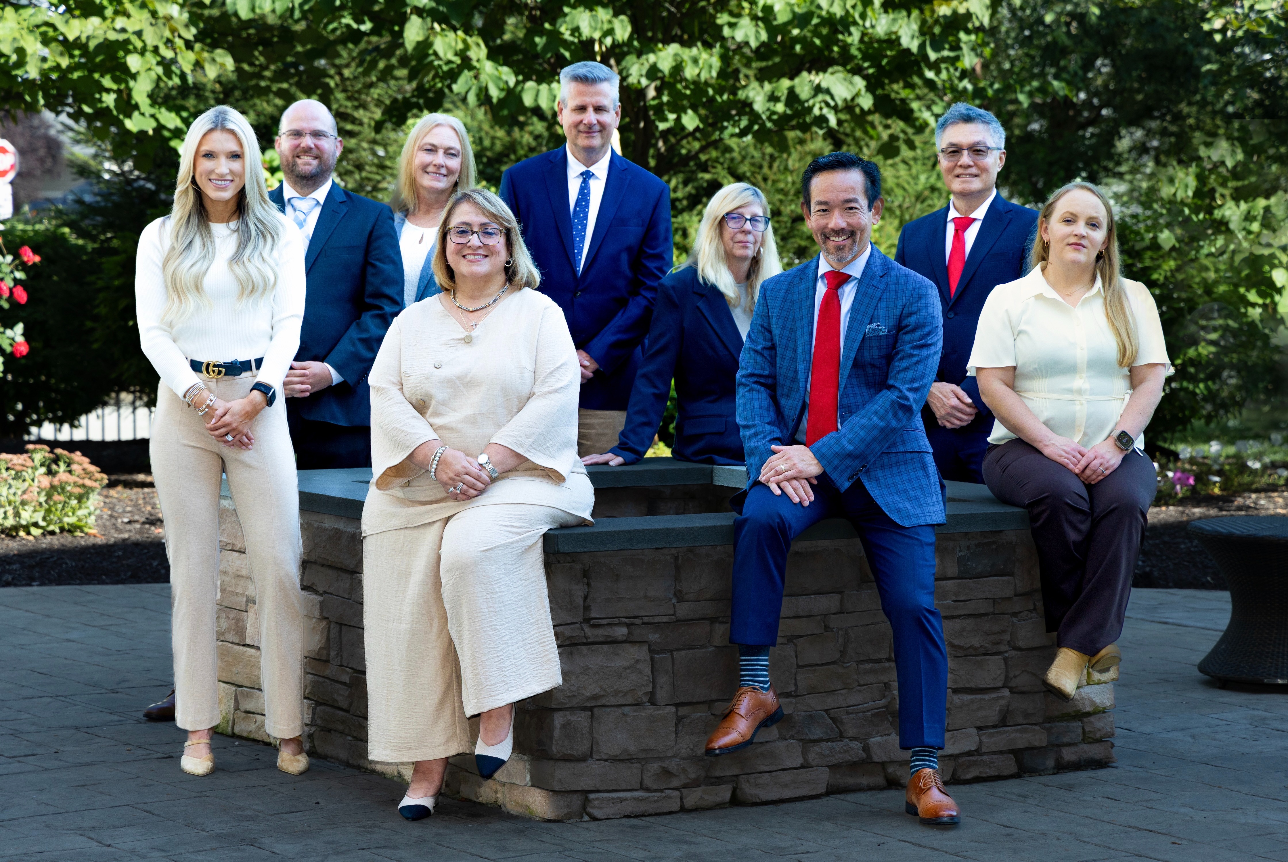Four men and six women in professional clothing, smiling at the camera
