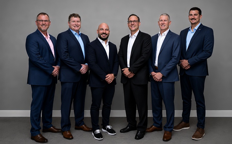 six men in business professional attire in front of white background