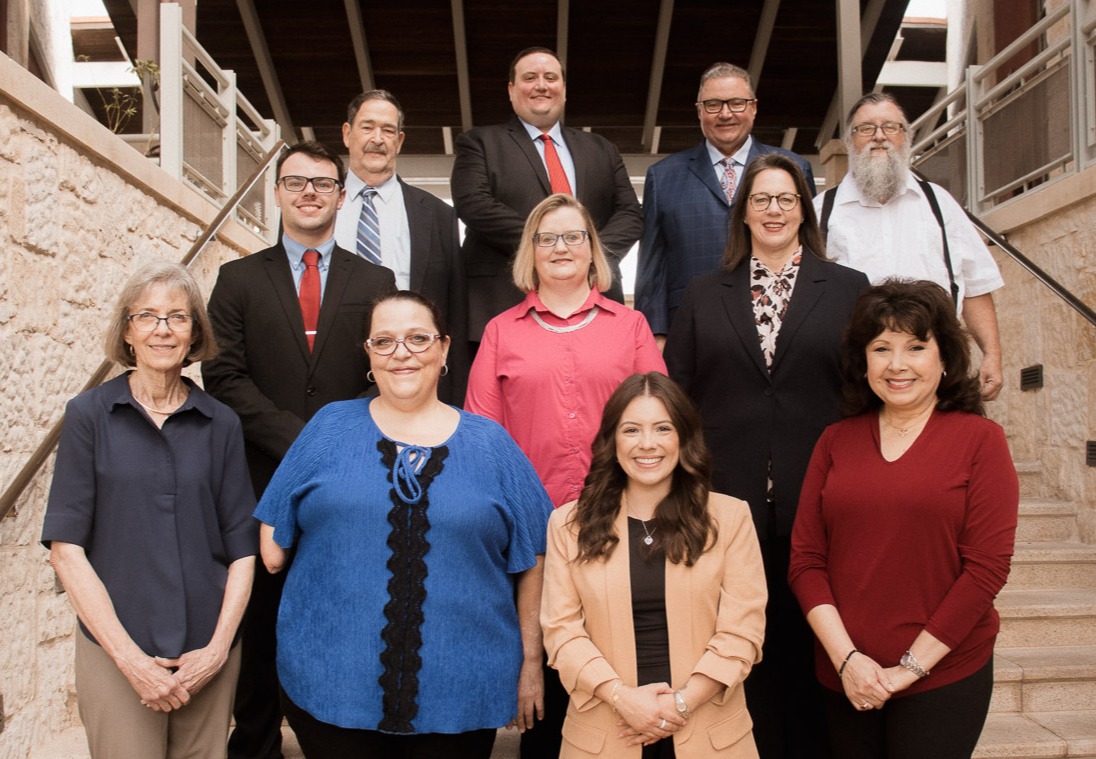 Groupofprofessionalmalessinfrontofnavycurtain